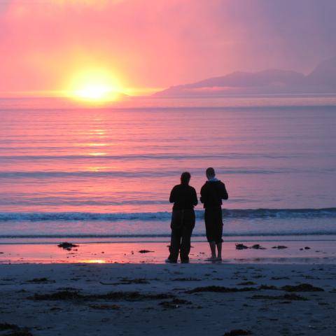 Two persons at the beach enjoying the midnightsun