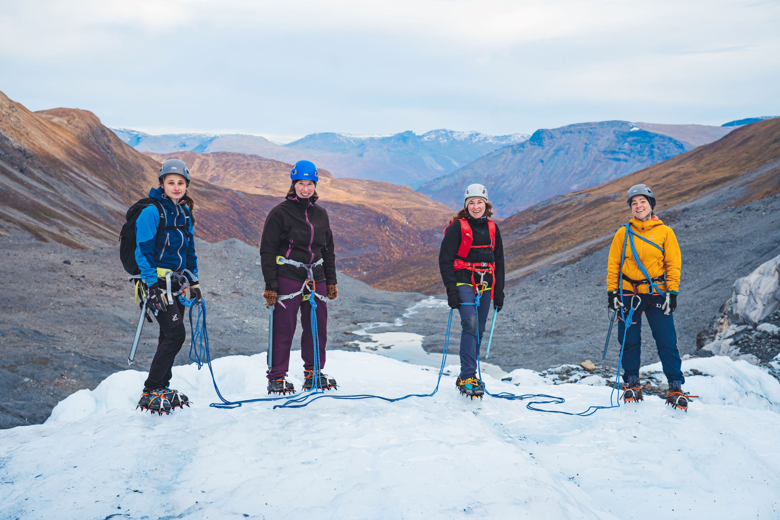 Four people standing on a glacier