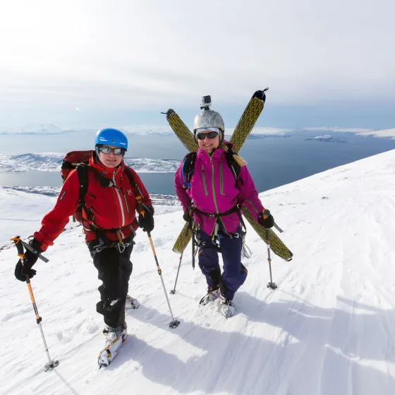 To skigåere på toppen av Russelvfjell, med fjorden i bakgrunnen