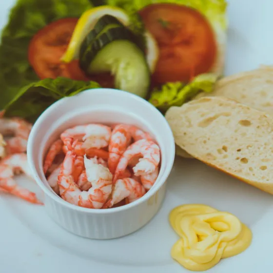 shrims, salad, bread and butter on a plate