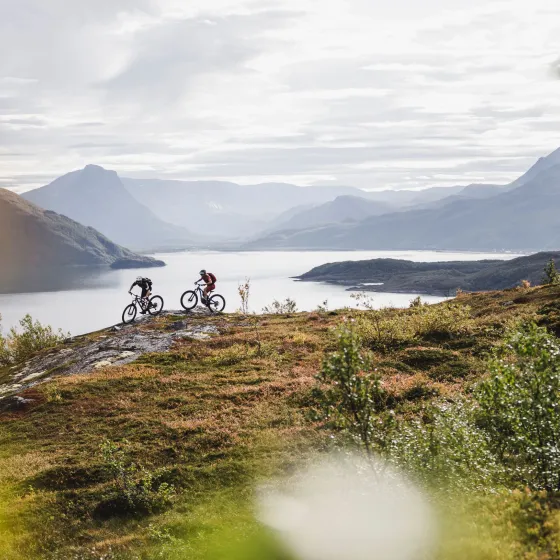 To stisyklister på tur, Lyngenfjorden i bakgrunnen
