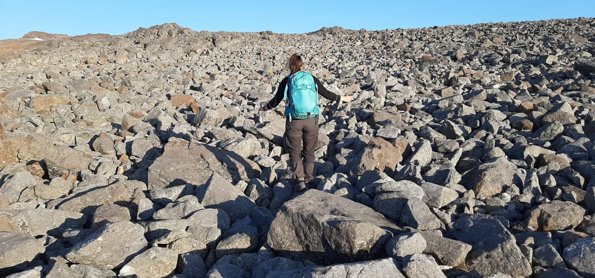 Person walking on rocky mountain slope