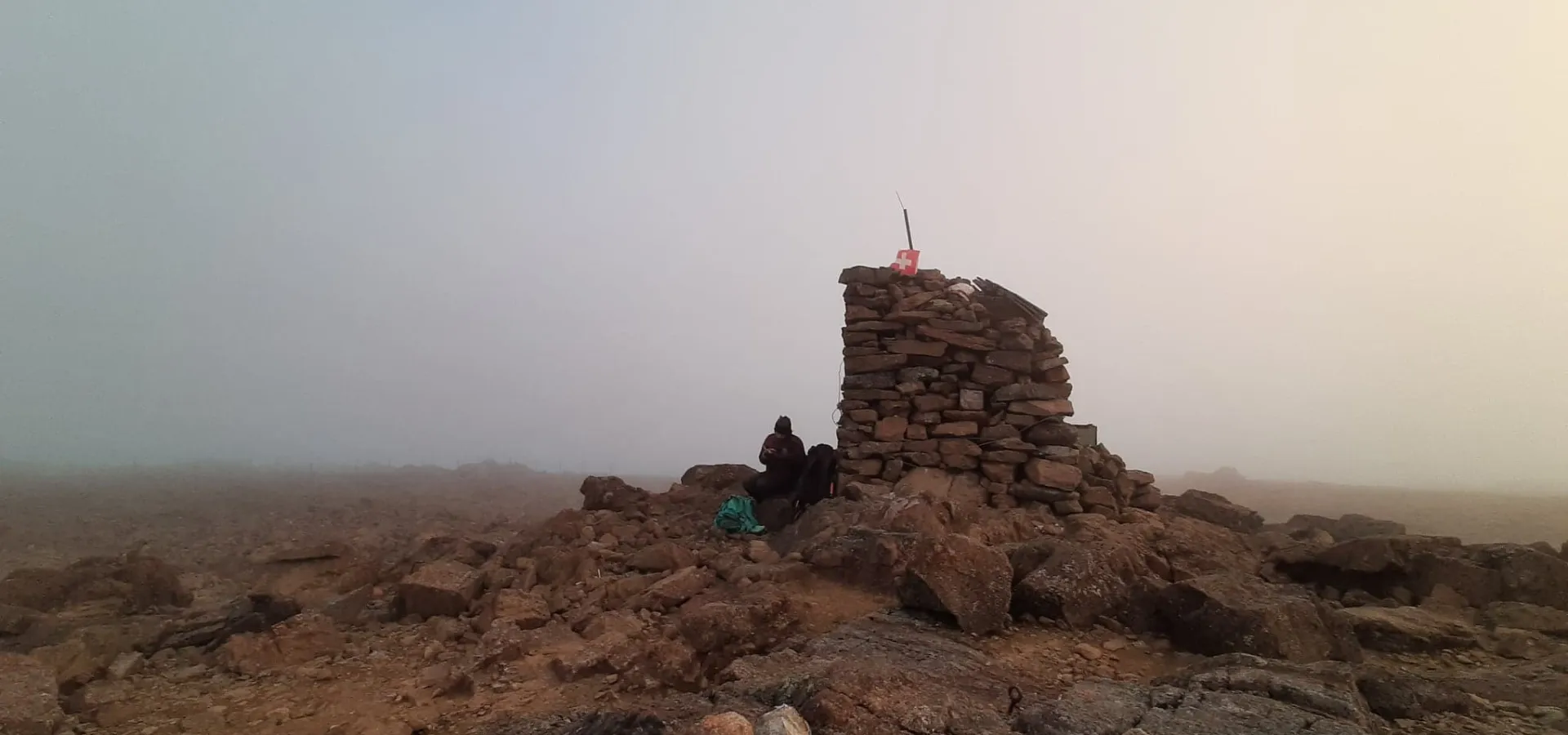 Rocky landscape and huge rock border cairn in mist