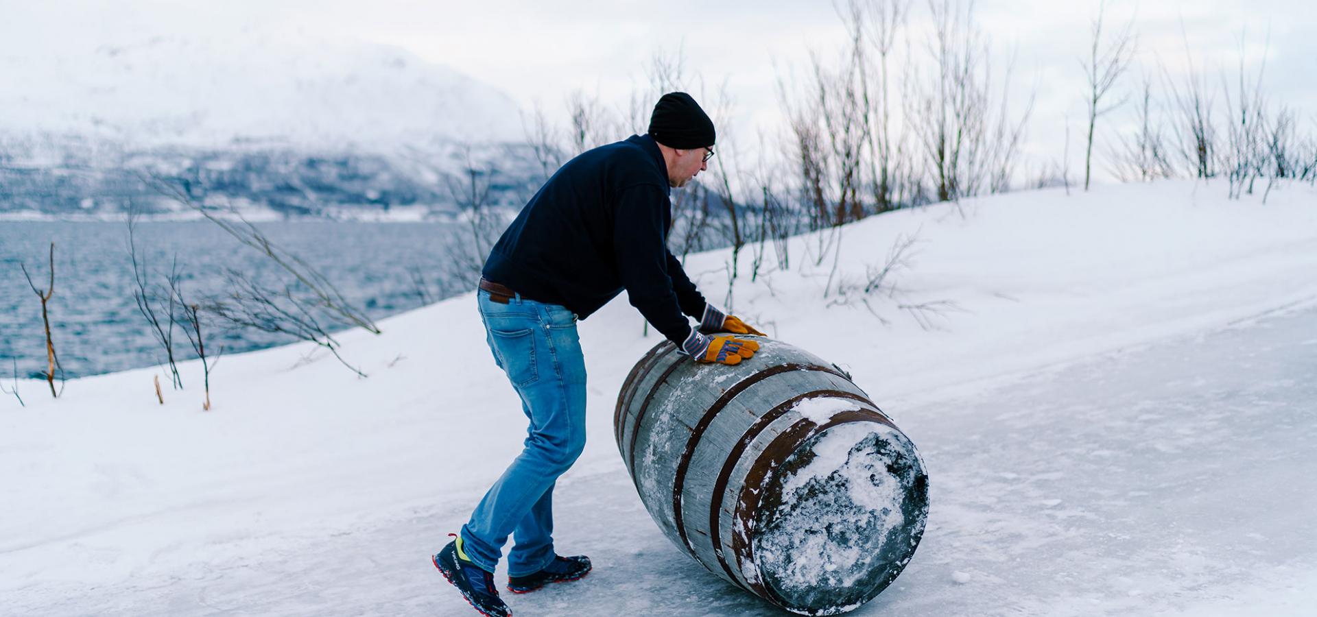 Rolling a whisky cask at Aurora Spirit wintertime in Lyngen, Northern Norway