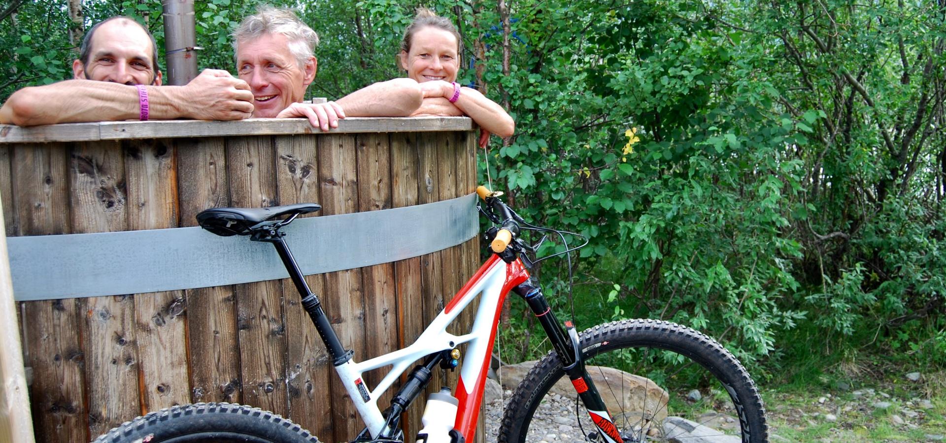 3 people in the hot tub and a mountain bike in front