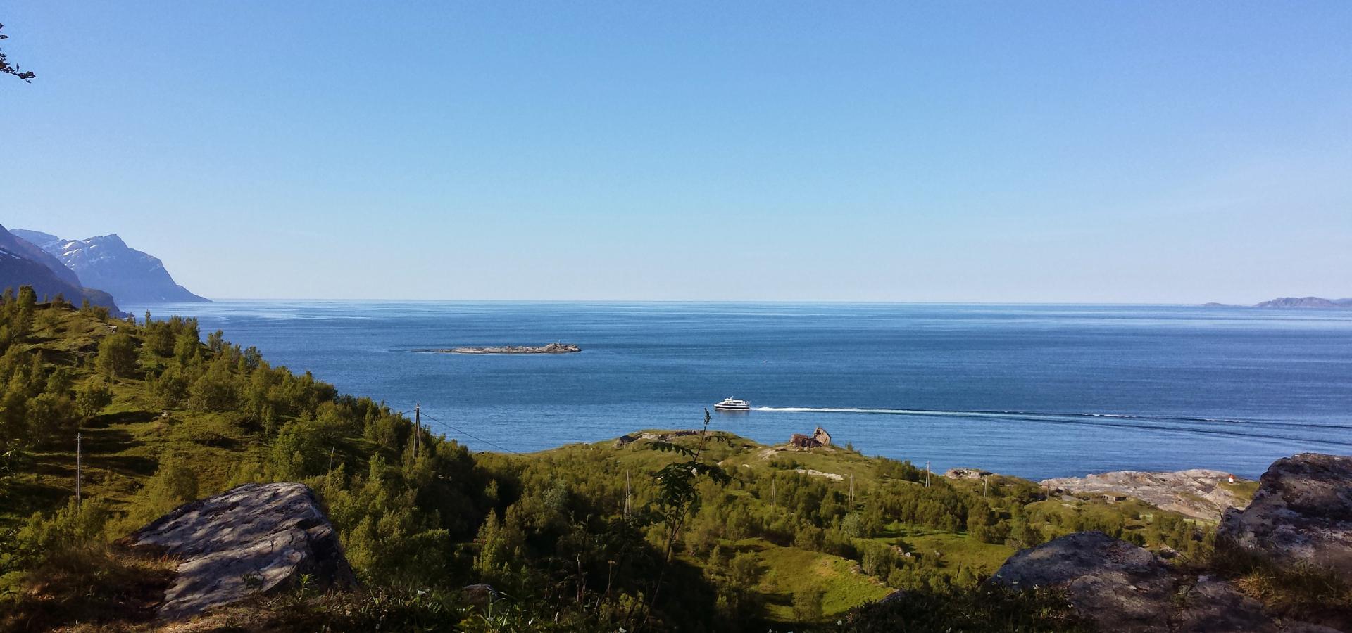 View of the sea and horizon on a sunny day, in front a nature area