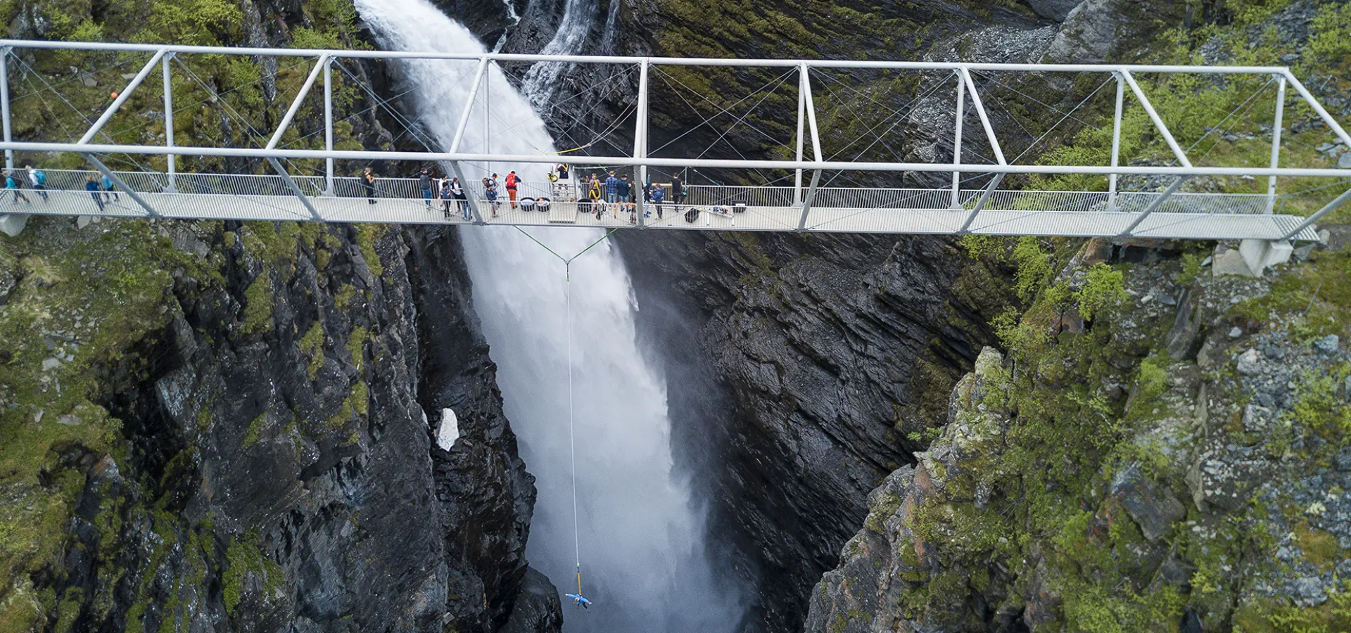 Bungee jumping going on from a metal bridge over a deep canyon