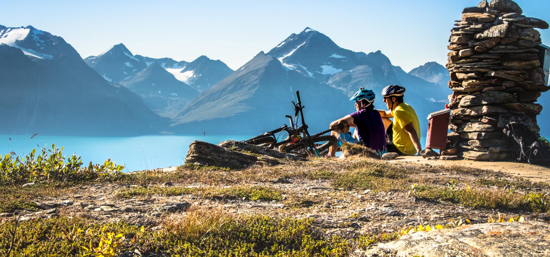 To syklister på Dalberget som nyter utsikten over Lyngenfjorden