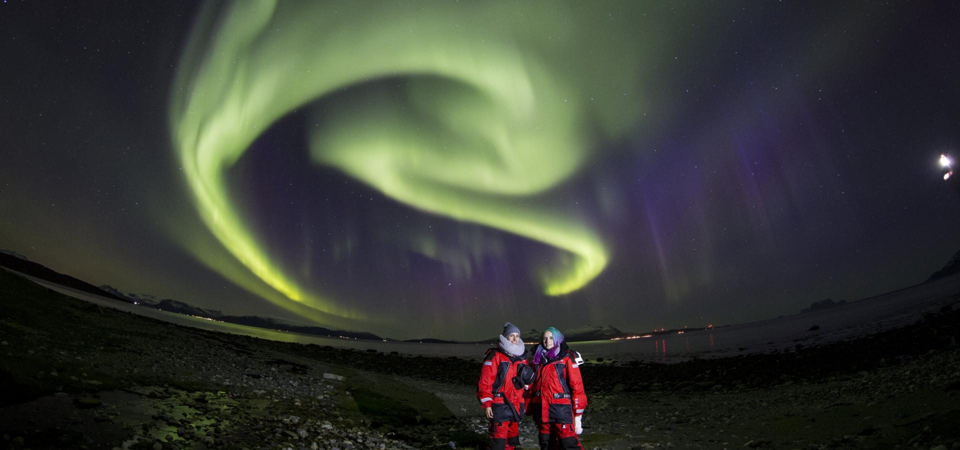 Two guests under the Northern Lights by the Lyngenfjord