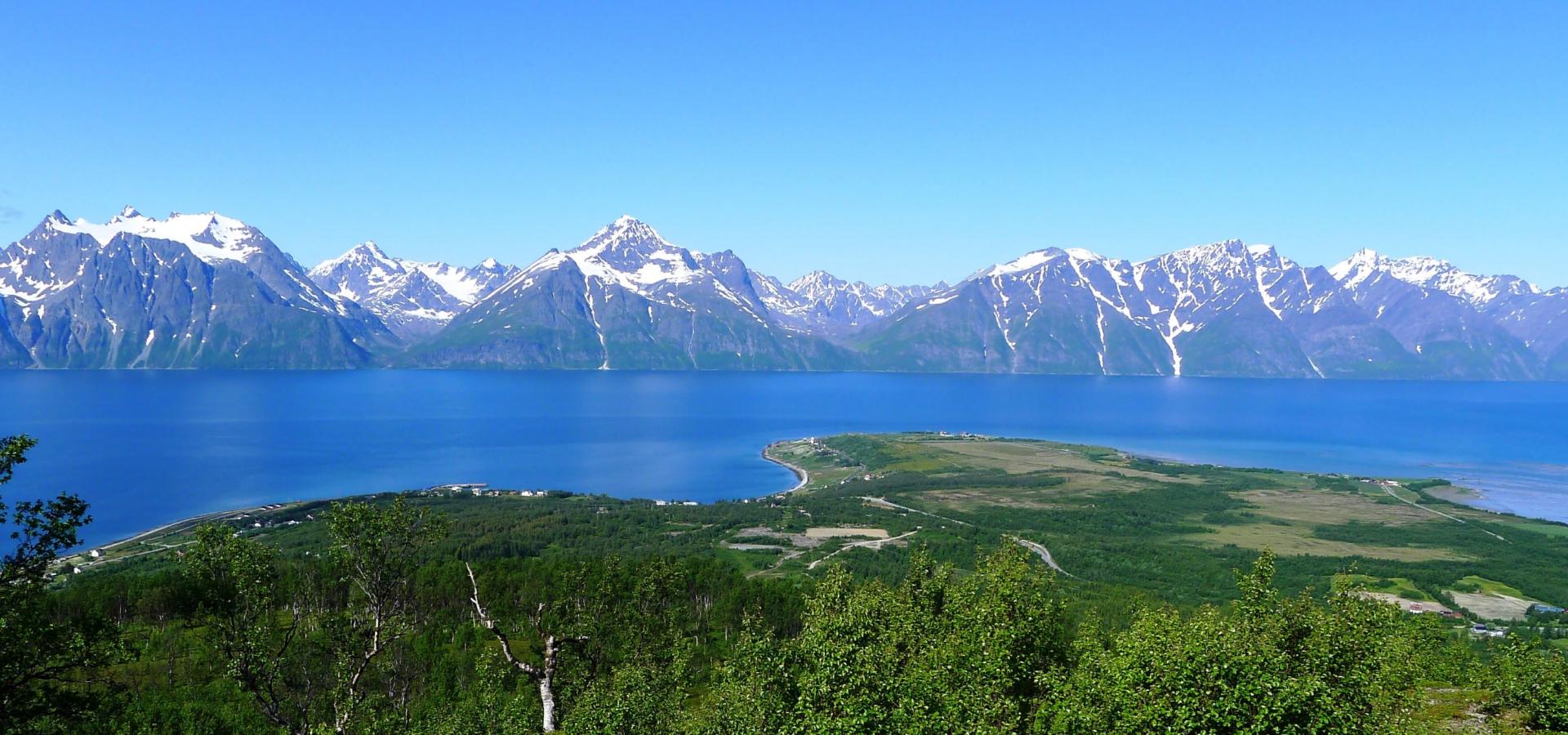 View of the peninsula Spåkenes from above, the Lyngenfjord and the Lyngen Alps in the background
