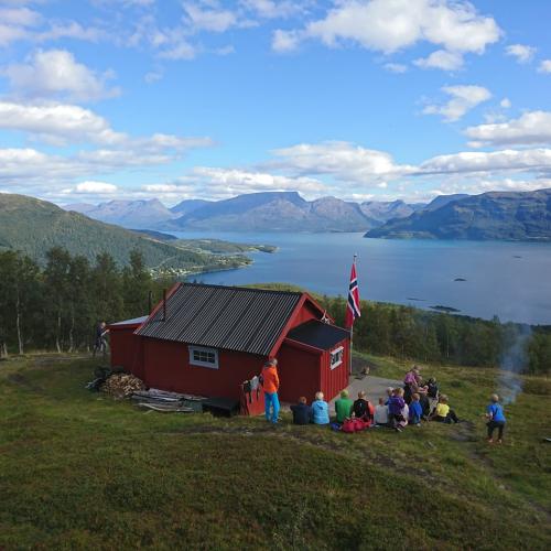 Red cabin in the mountains with views towards the fjord and mountains