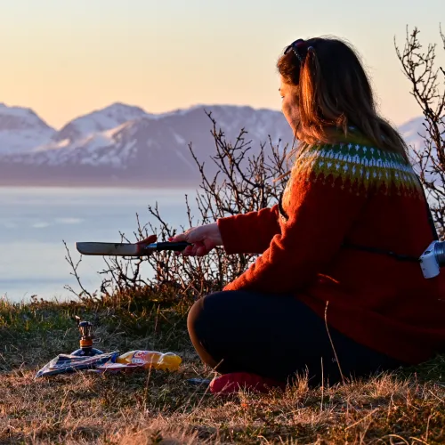 Woman sitting on the ground making dinner