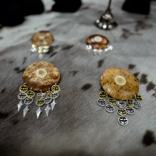 Four silver brooches made of tree and bone, lying on a gray sealskin
