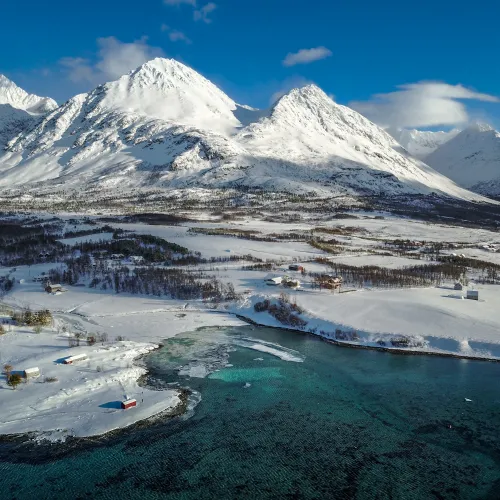 Vinterlandskap badet i sollys tatt med drone