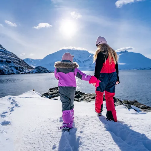 Et barn og en dame går ut mot havet