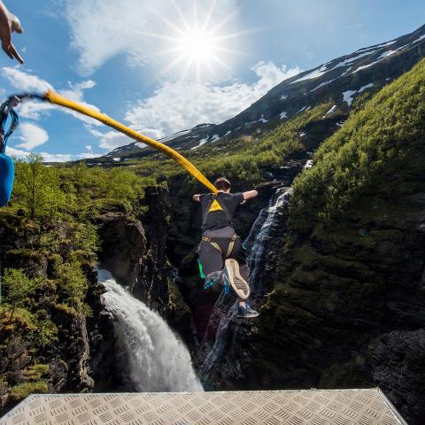Person doing a bungee jump to a deep gorge