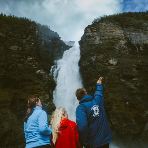 Three people looking at a waterfall (Mollisfossen)