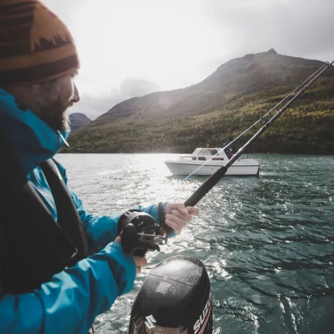 A person fishing on the Lyngenfjord in greyish weather