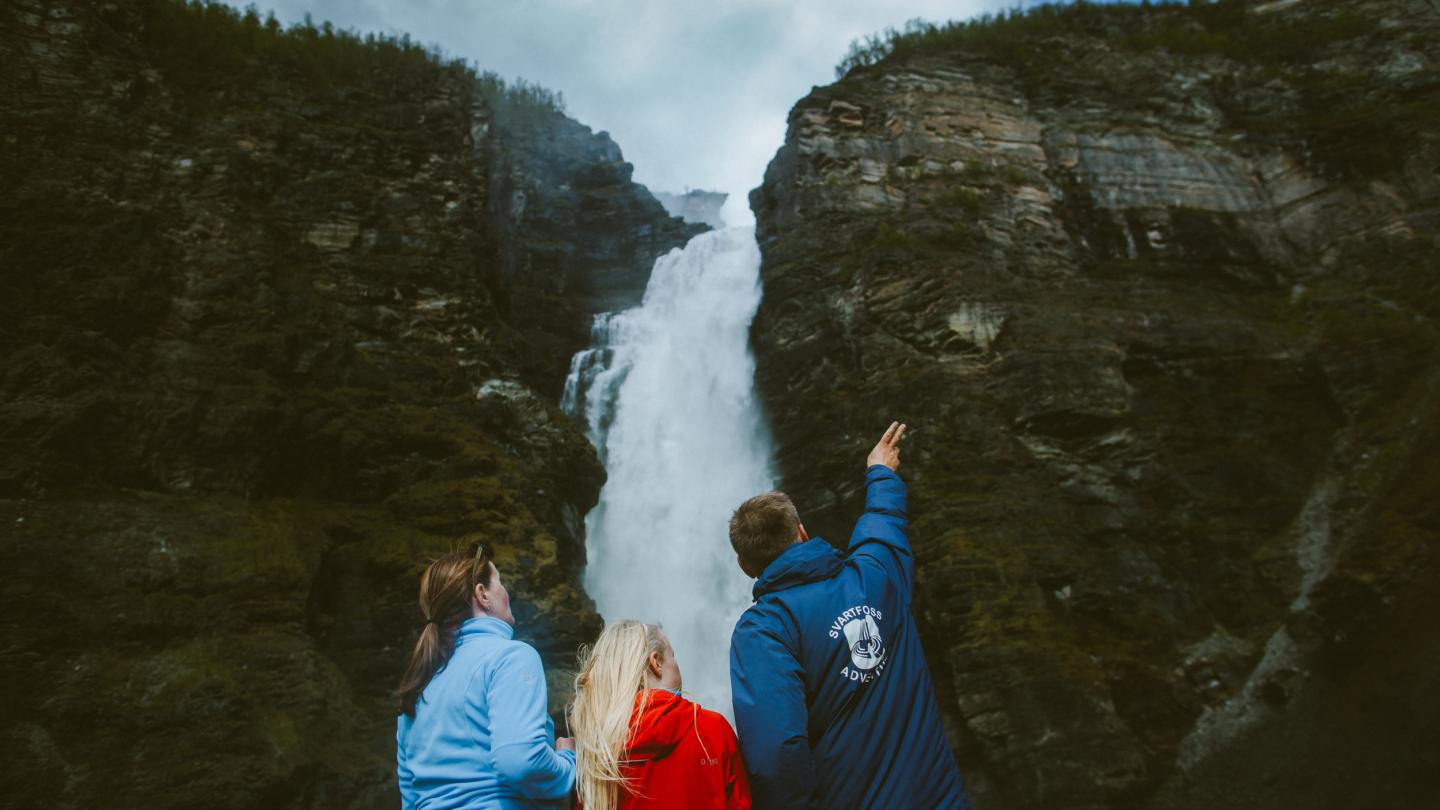 Tre personer som ser på et fossefall, Mollisfossen