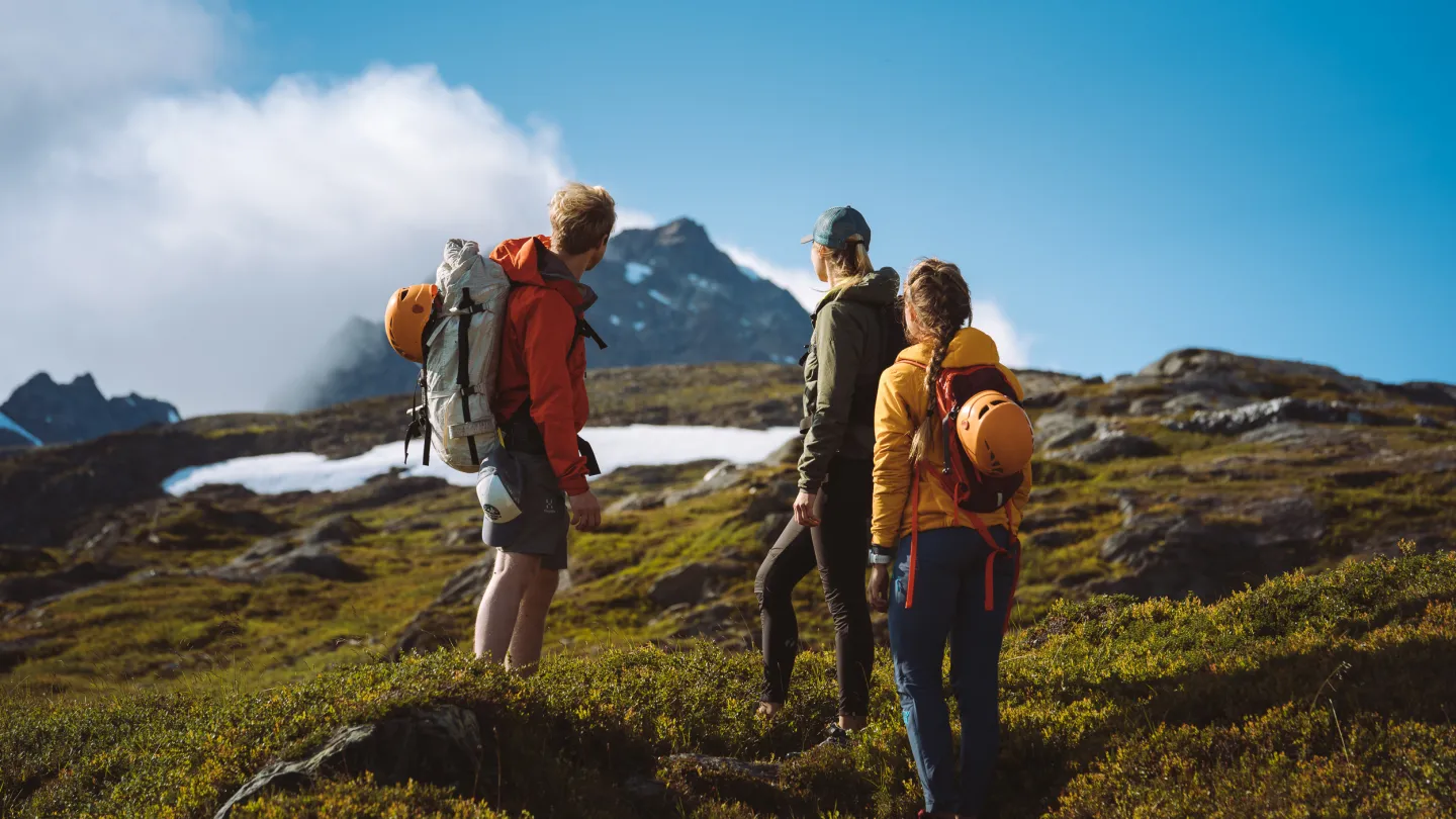 3 persons hiking in the mountains on a sunny day