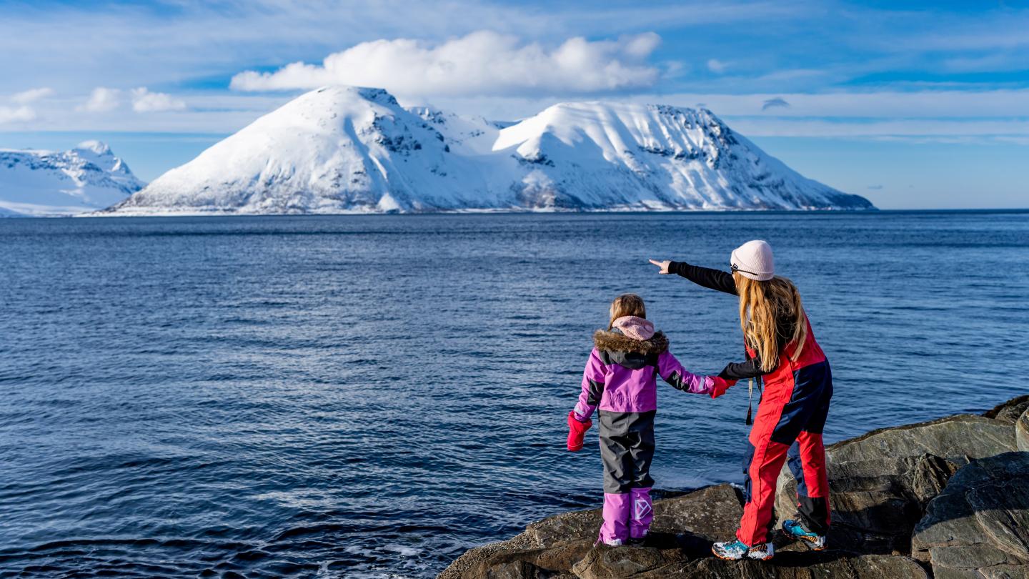 Mor og datter ser utover sjøen en vårdag i nordnorge