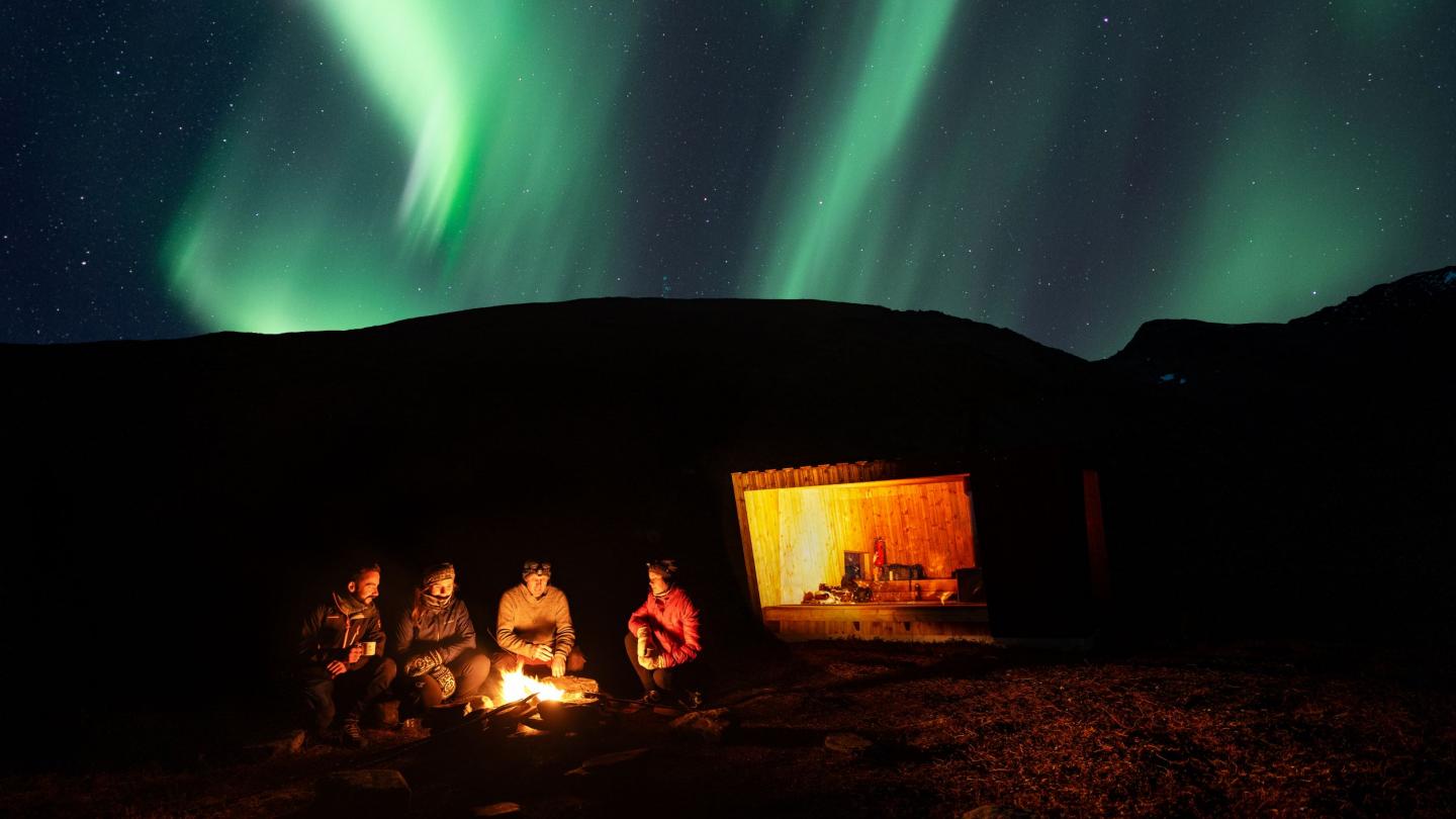 Bonfire and northern lights at Dalberget in Northern Norway