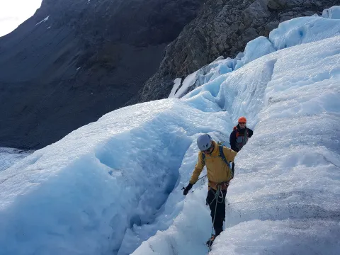 To personer går på en isbre.