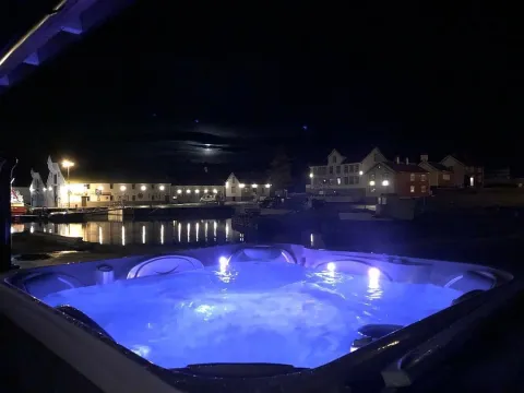 Et nattbilde av en jacuzzi med blått lys i vannet