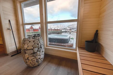 Sauna med panoramavindu, en jacuzzi står rett utenfor vinduet
